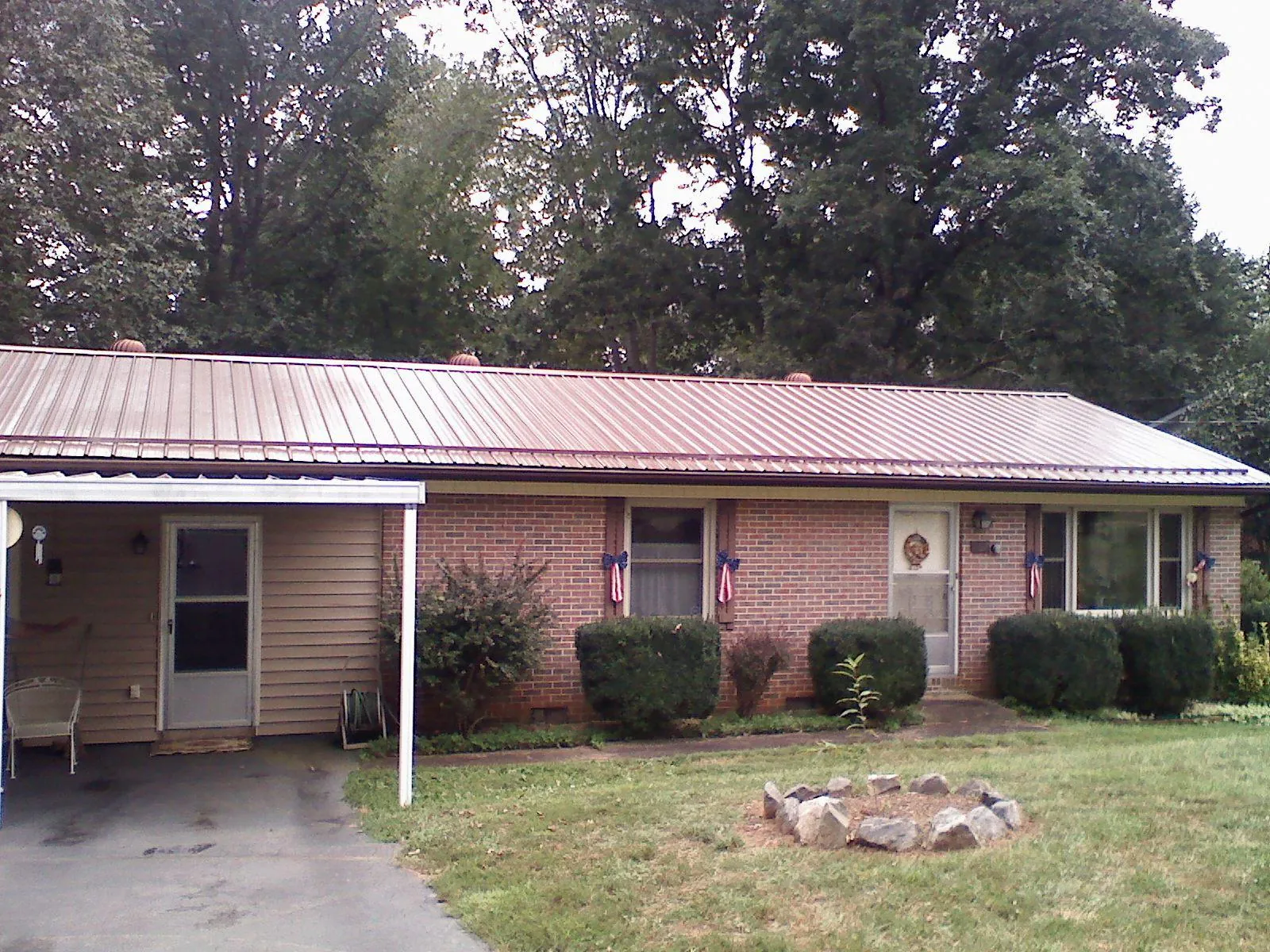 Bronze metal roof and carport on a brick ranch home — Roof Repair work by our crew in Kenyon